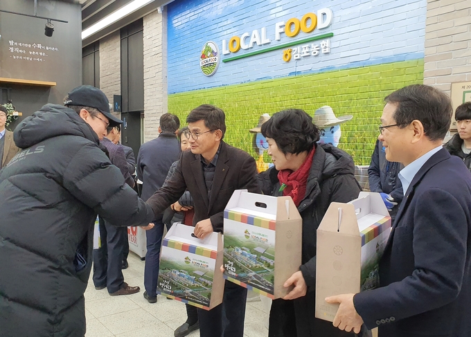 (오른쪽부터) 농업경제지주 김원석 대표이사, 김포농협 김명희 조합장, 고촌농협 조동환 조합장이 1일 김포농협 로컬푸드직매장을 방문한 고객에게 김포지역 로컬푸드 꾸러미를 증정하고 있다.