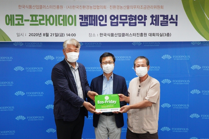 주형로 친환경농산물자조금위원장(사진 우측)과 김영재 한국친환경농업협회장(사진 좌측)이 윤태진 한국식품산업클러스터진흥원 이사장(사진 중앙)에게 에코프라이데이 현판을 전달하고 있다.