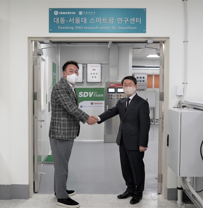 대동 원유현 대표이사와 협력 사업 총괄 책임인 서울대 원예학 강병철 교수가 행사 후 경기상상캠퍼스에 있는 대동과 서울대가 공동 운영하는 스마트팜 연구센터 앞에서 기념 사진을 촬영하고 있다.