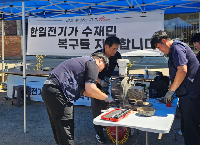 한일전기 임직원들이 수해지역의 펌프와 가전제품을 무상 수리하고 있다.