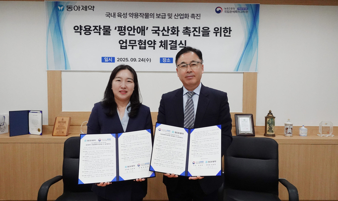 <strong>농촌진흥청 국립원예특작과학원 박정관 인삼특작부장(오른쪽)과 동아제약 윤춘희 연구소장이 우리 약용작물 품종의 생약 원료 확대를 위한 업무협약을 체결한 뒤 협약서를 들어 보이고 있다.<사진=농촌진흥청></strong>